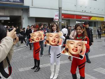 Fotomontage, in dem drei asiatische Mädchen halten Schilder mit Ihrem Bild, auf der Straße, mit großer Vorfreude.